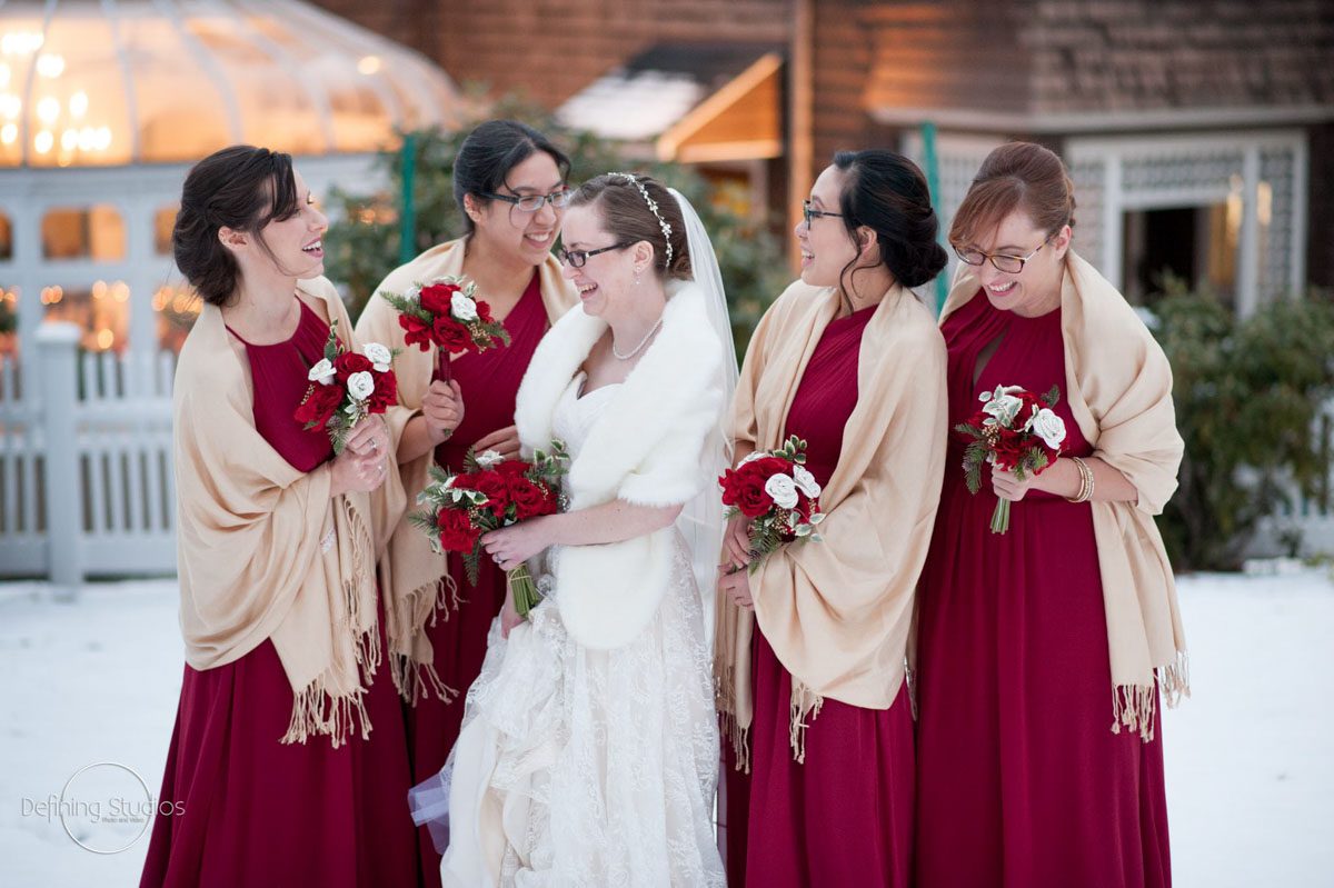 A Winter Wedding bride-bridesmaids-laughing-outside-in-snow-at-christmas-wedding
